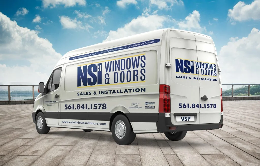White van parked outside with window company’s information displayed on the side