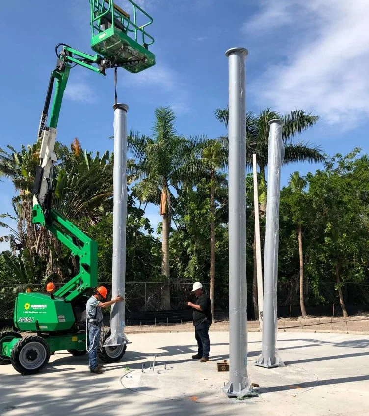 Workers installing metal pendulum towers at the Palm Beach Zoo.